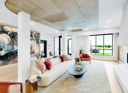 A modern living room with a white couch and a fireplace.