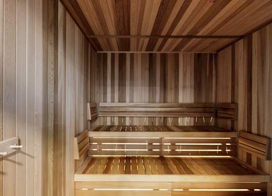 A wooden sauna with benches and a railing.