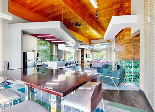 A modern dining room with a long table and chairs.