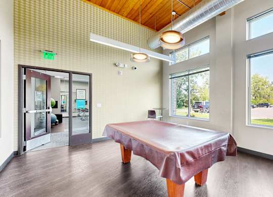 A room with a table and chairs and a view of the outside.