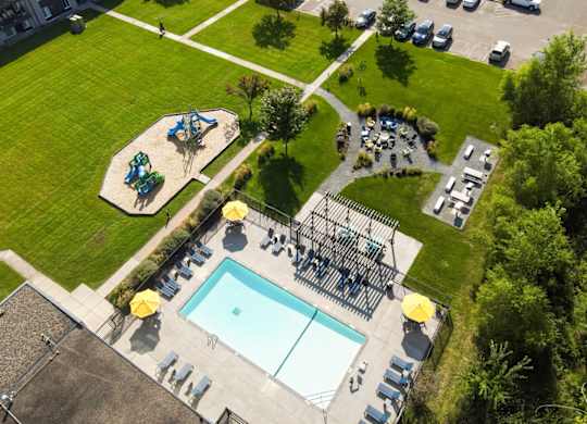 A playground with a slide, swimming pool and a play area.