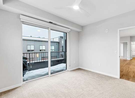 A room with a large window and sliding glass doors.