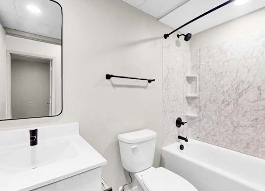 A white bathroom with a toilet, sink, and bathtub.