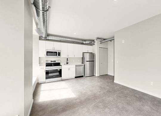A kitchen area with a microwave, oven, and refrigerator.