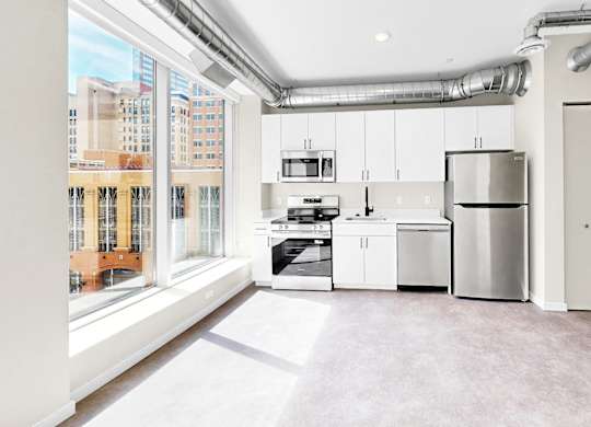 A kitchen with white appliances and cabinets is shown.