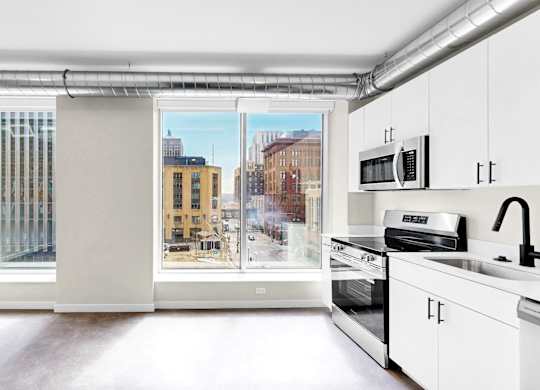 A kitchen with white cabinets and a stove top oven.