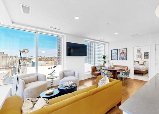 A living room with a yellow couch and a flat screen TV.