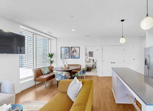 A modern kitchen with a yellow sofa and a wooden floor.