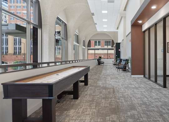 A long hallway with a bench and a person walking.