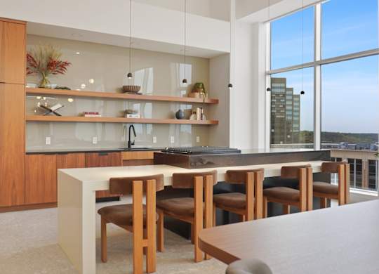 A modern kitchen with a large island and a view of the city.