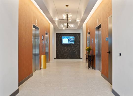 A long hallway with a TV mounted on the wall at the end.