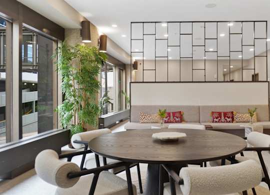 A modern dining room with a round table and chairs.