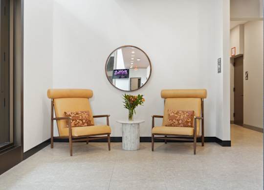Two chairs and a table with a vase of flowers on it.