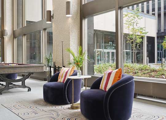 A room with a table and chairs and a plant.