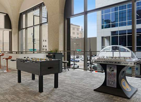 A foosball table is in the middle of a room with a pool table in the background.