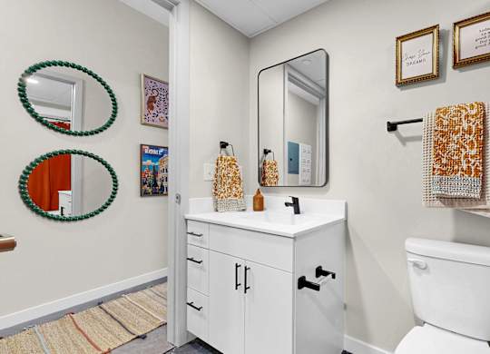 A white toilet sits next to a white cabinet in a bathroom.