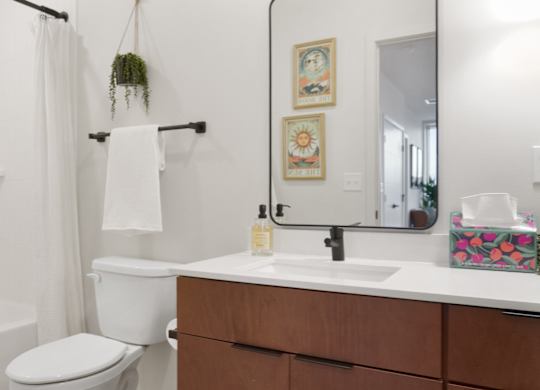 A white toilet sits next to a white sink in a bathroom.