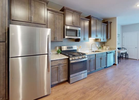 a kitchen with stainless steel appliances and wooden floors