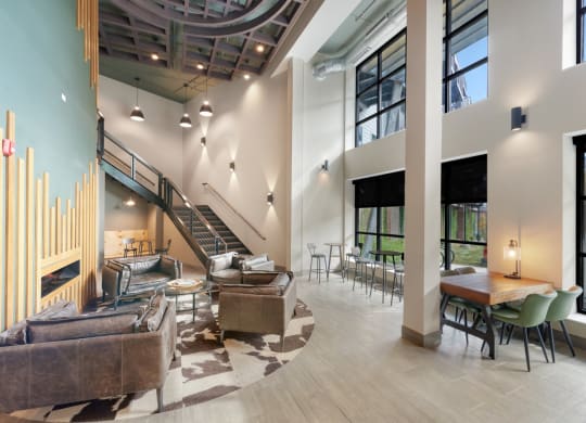 a lobby with couches chairs and tables and a staircase