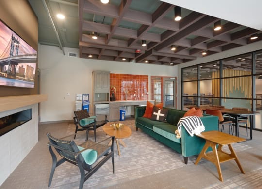 a living room with a green couch and chairs and a television