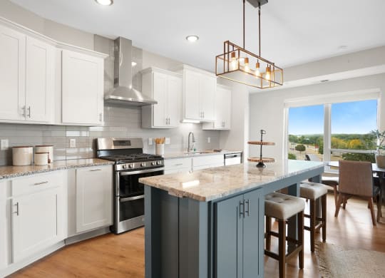 a kitchen with a large island and a stove and a window