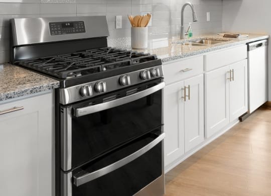 a white kitchen with stainless steel appliances and white cabinets