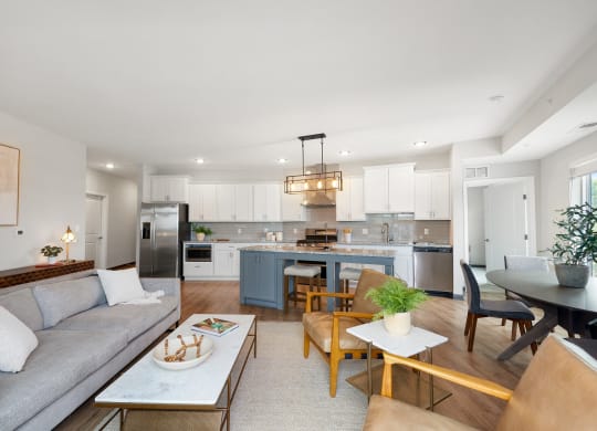 a living room with a couch and a kitchen with a table and chairs