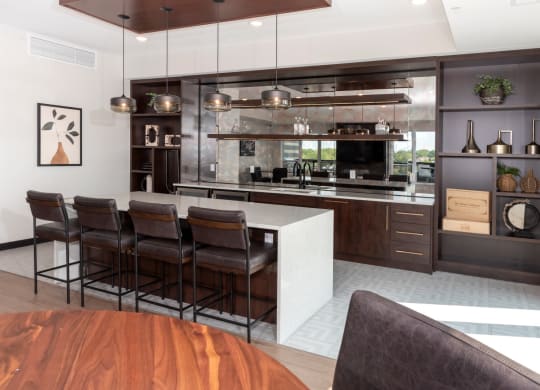 a kitchen with a large center island with a white countertop at The Exchange Apartments, New Brighton, MN 55112