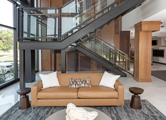 a living room with a couch in front of a staircase at The Exchange Apartments, New Brighton, 55112
