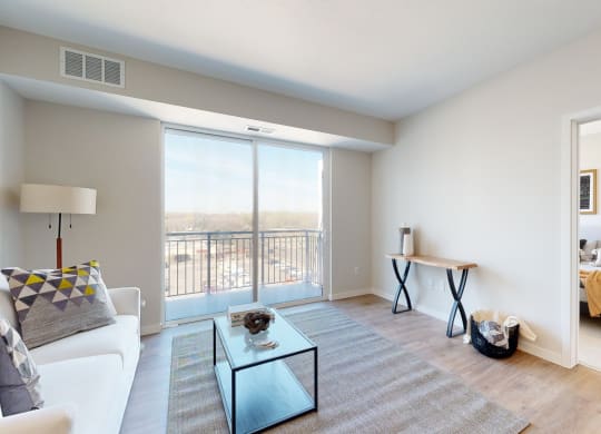 a living room with a large window and a view of a bedroom at The Exchange Apartments, Minnesota, 55112