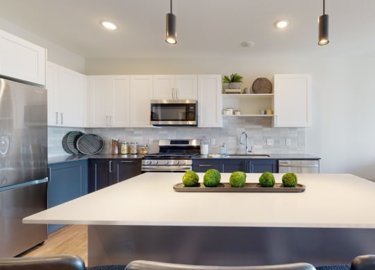 a kitchen with white cabinets and stainless steel appliances at The Exchange Apartments, New Brighton, MN