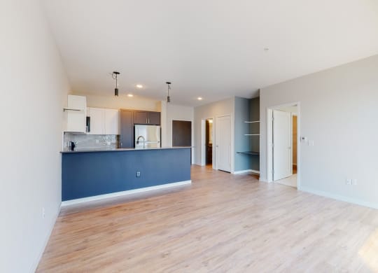 an empty living room with a kitchen at The Exchange Apartments, New Brighton, 55112