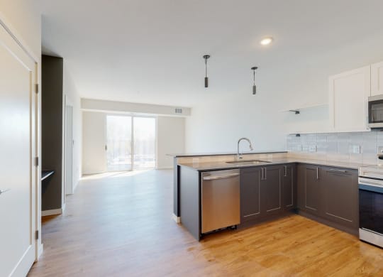 a kitchen with white cabinets and a wooden floor at The Exchange Apartments, Minnesota