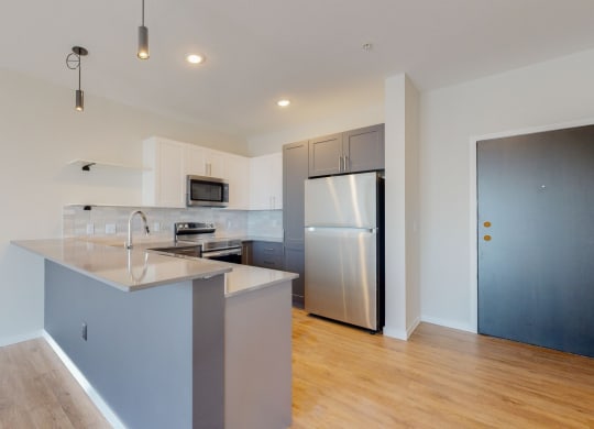 a kitchen with a large island and stainless steel appliances at The Exchange Apartments, New Brighton, MN