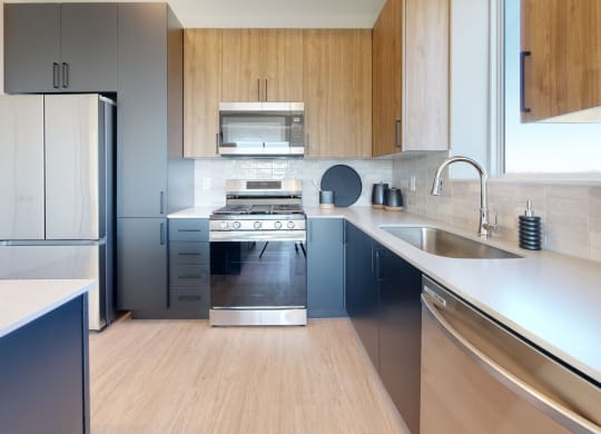 a kitchen with a stove top oven next to a sink at The Exchange Apartments, Minnesota, 55112