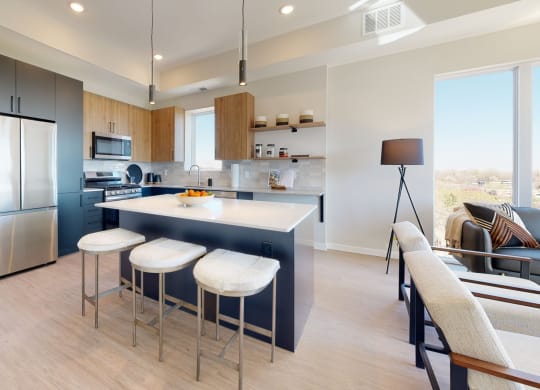 a kitchen with a large center island with three stools at The Exchange Apartments, Minnesota