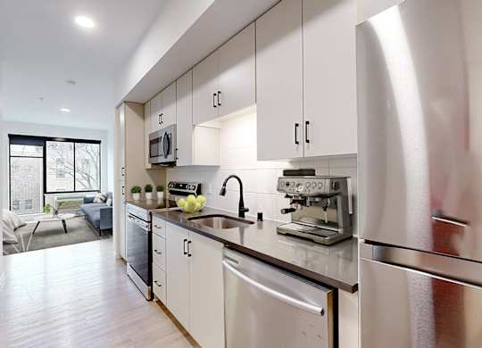 A modern kitchen with stainless steel appliances and white cabinets.