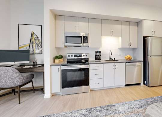 A modern kitchen with stainless steel appliances and white cabinetry.