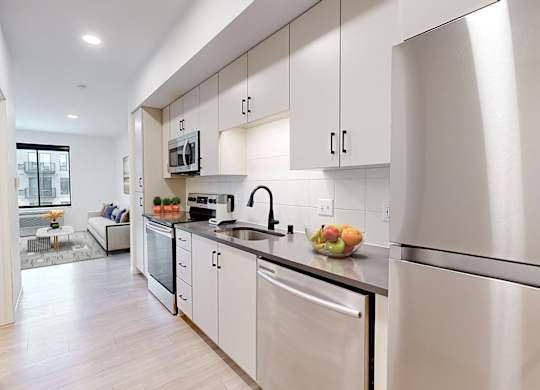 A modern kitchen with stainless steel appliances and white cabinets.