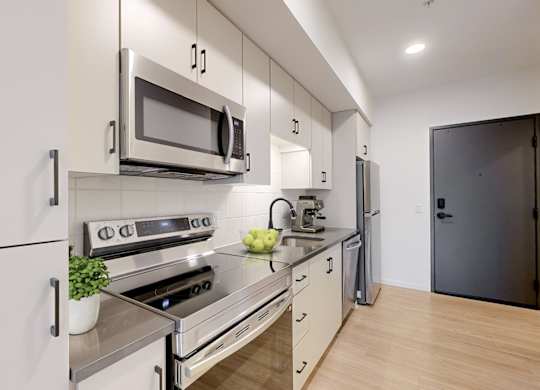 A modern kitchen with a stove, oven, microwave, and refrigerator.
