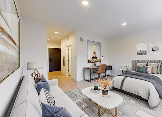A modern bedroom with a large bed and a couch.