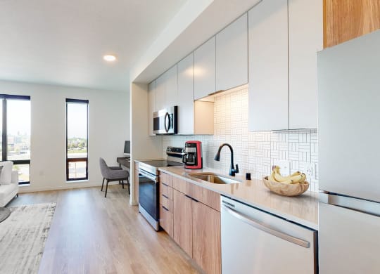 an open kitchen and living room with a view of the city at The Mason, St. Paul, 55114