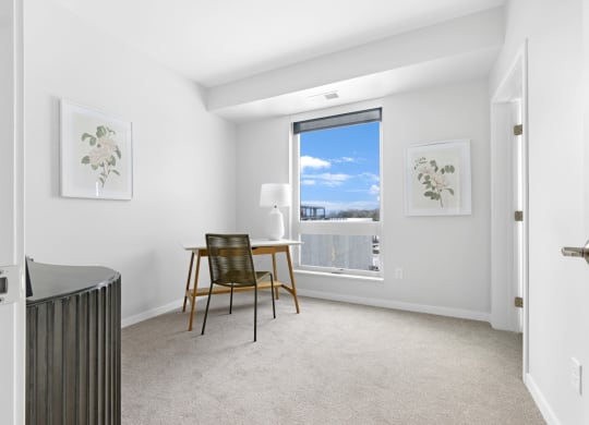 a bedroom with a desk and a window
