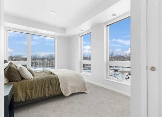 a bedroom with a bed and three windows