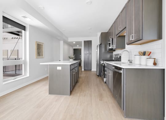 a kitchen with gray cabinetry and white countertops
