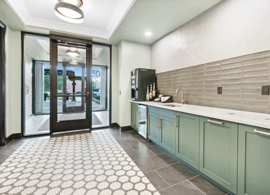 a kitchen with green cabinets and a white tile floor
