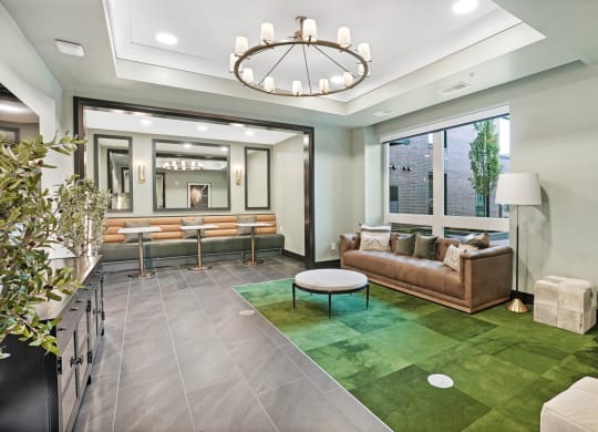 a living room with a green rug and a large chandelier