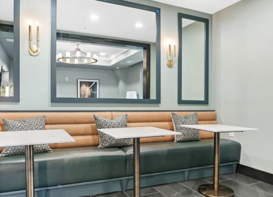 a seating area with two tables and two mirrors