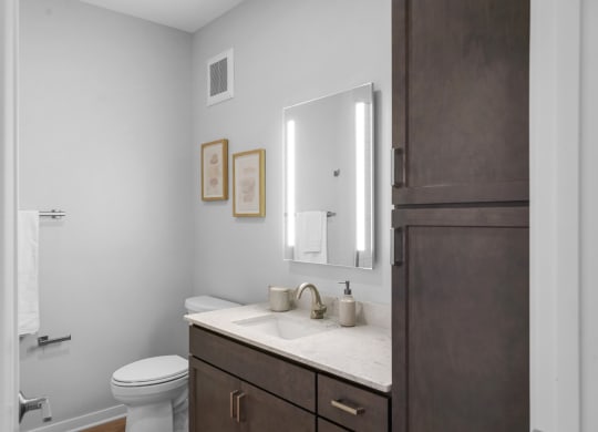 a bathroom with gray walls and a white sink and toilet