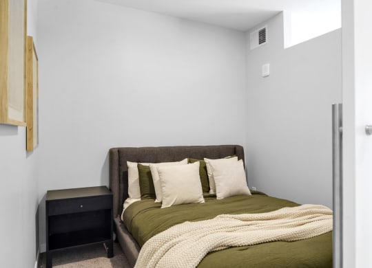 a bedroom with a bed and a nightstand in a 555 waverly unit